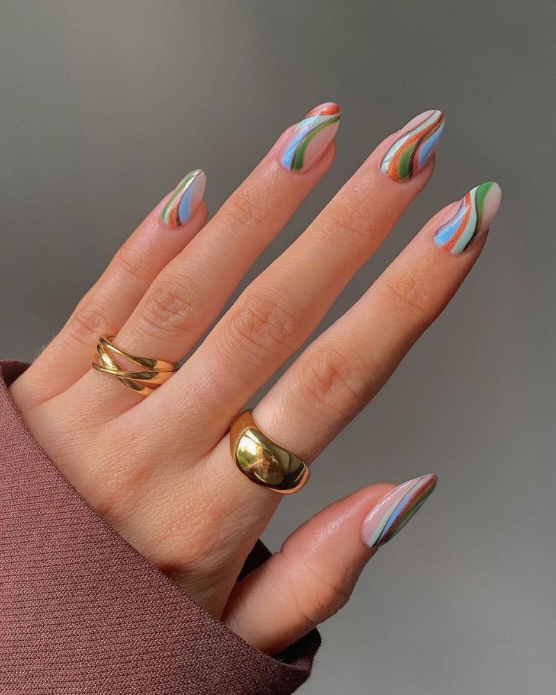 cute fall nails with a colorful swirly nail art in shades of brown, green, orange and blue