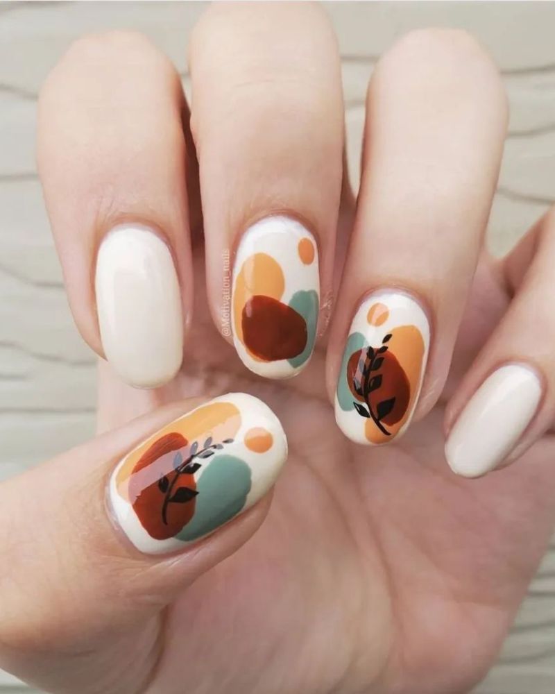 easy nail art for autumn with creamy white base and splashes of fall colors