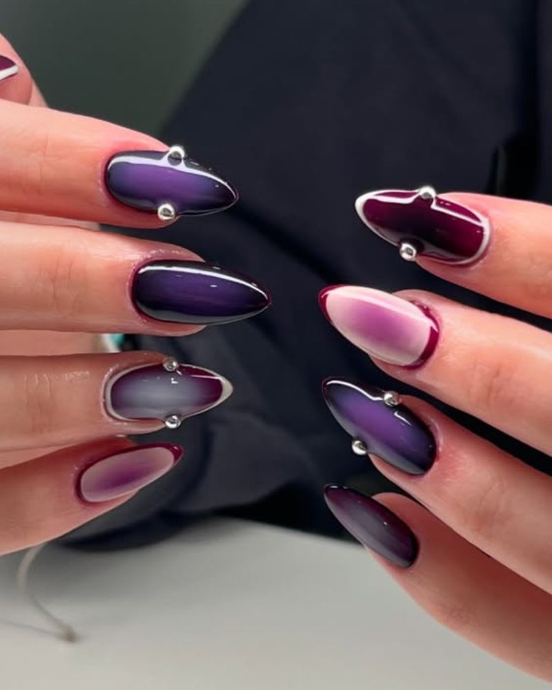 dark purple cat eye nail design with plum accents