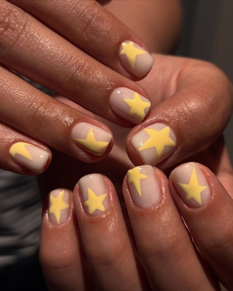 short square nails with a milky white base and yellow star nail art