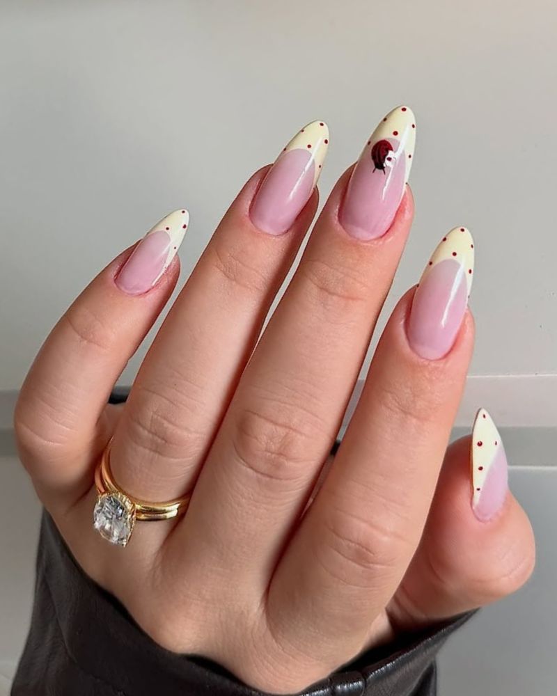 long almond nails with pastel yellow french tips and polka dots