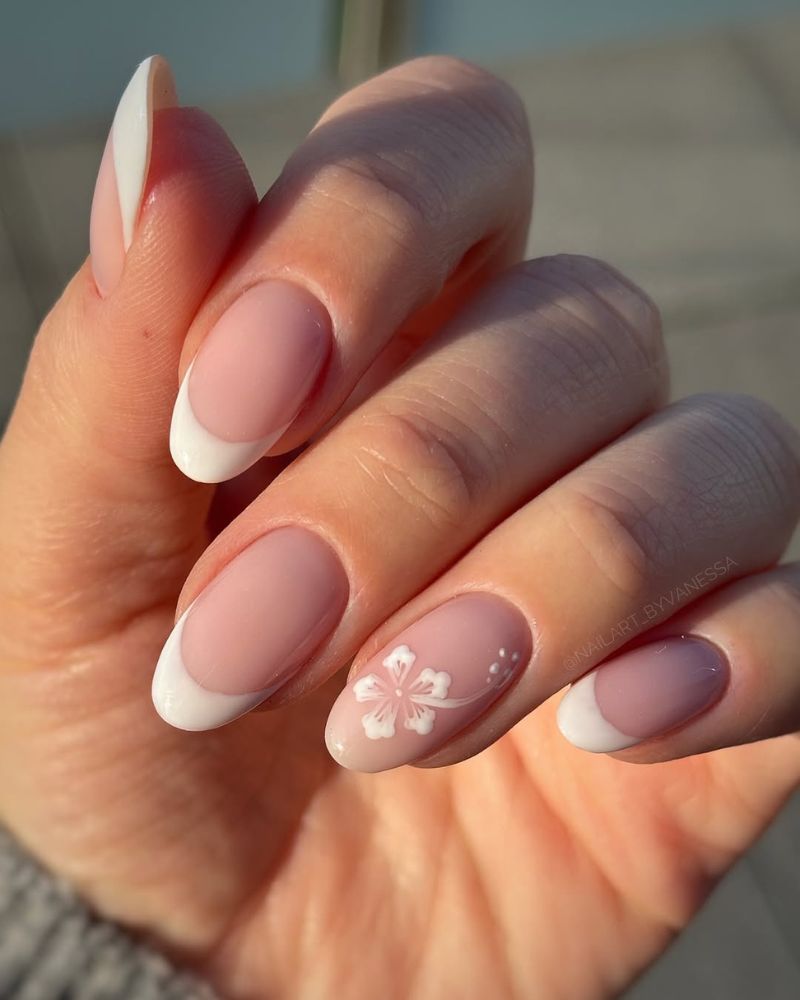 summer french tip nails in classic white with white flower accent shot in golden hour light