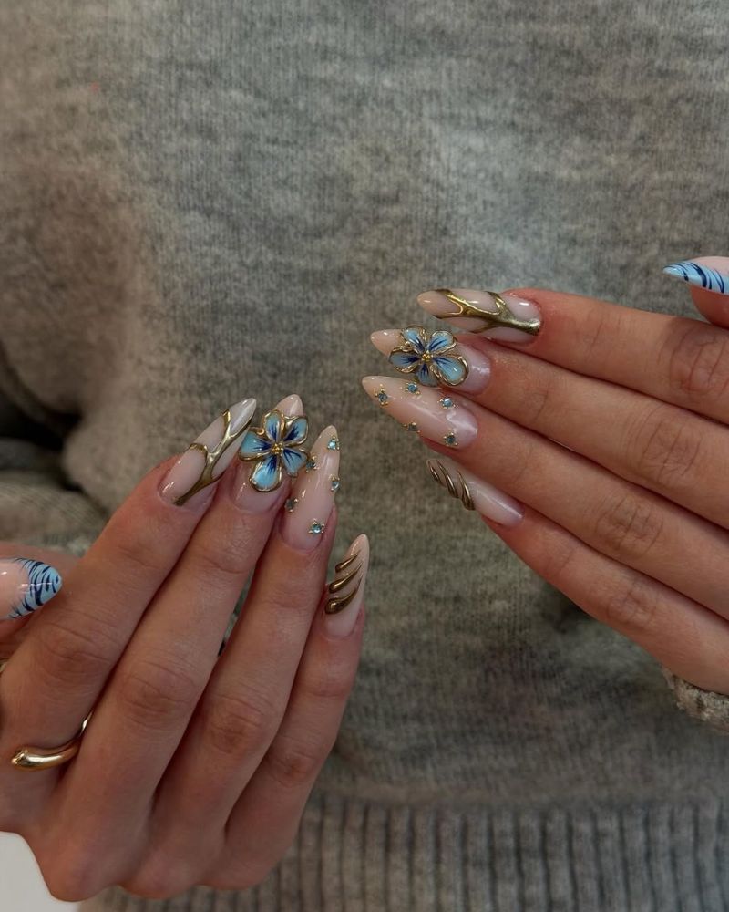 long stiletto nails with blue 3d flowers and gold nail art