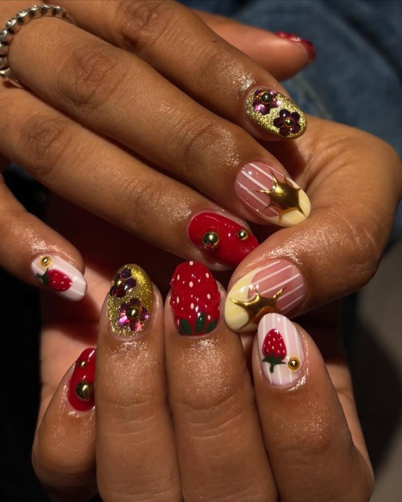 summertime nails designs with 3D strawberries, gold floral gems, and diagonal stripe accents
