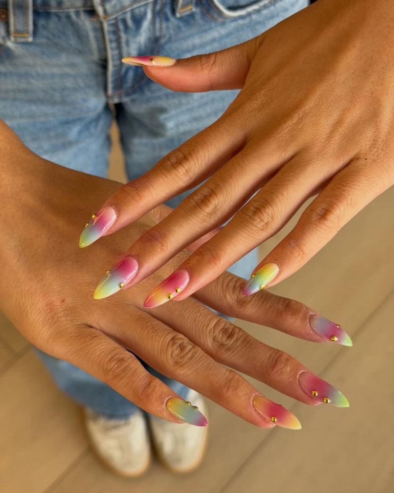 long stiletto nails with rainbow ombre and gold stud details
