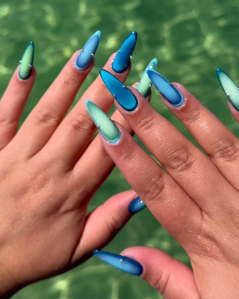 long almond nails with deep blue aura outline fading to mint and silver crystal studs
