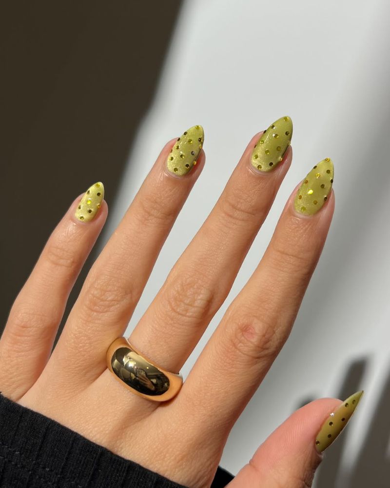 summer nail art designs with olive green cat eye base and scattered gold crystal dots