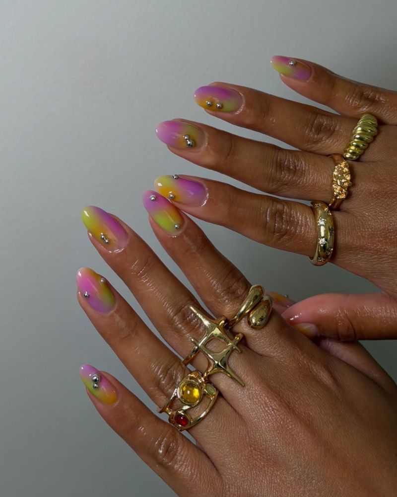 summer nail art aura ombre in yellow orange pink and purple with silver bead accents