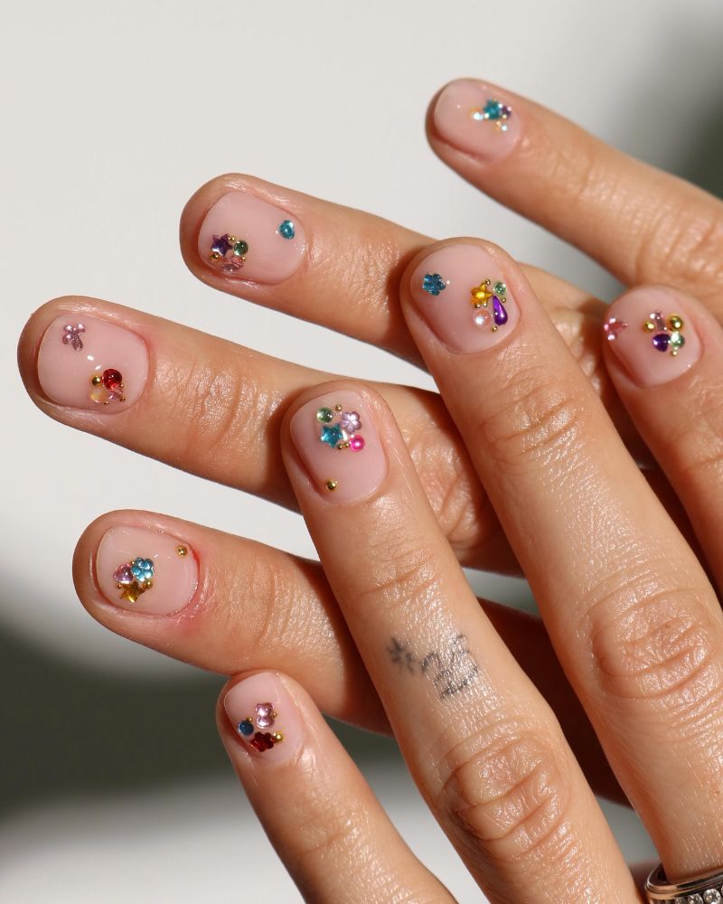 sheer nude short nails with multicolor rhinestone gem clusters