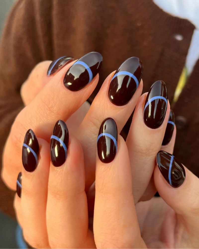 dark chocolate brown almond nails with single thin periwinkle blue curved line on each nail both hands brown cardigan