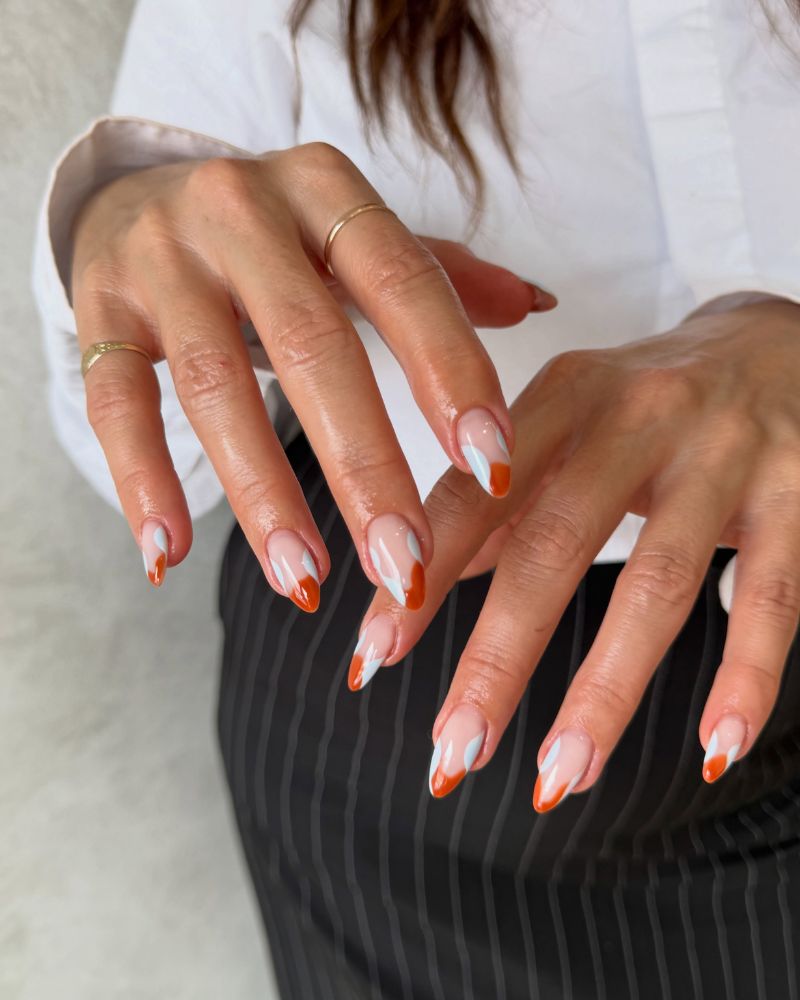 sheer nude almond nails with burnt orange abstract wavy french and white swoop