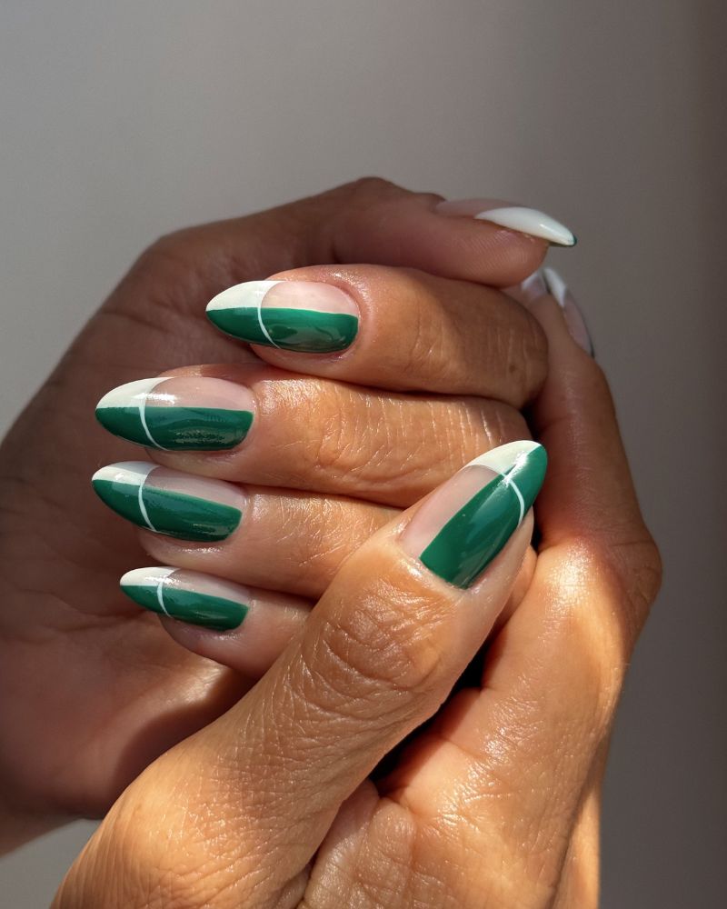 forest green bold french tip with white graphic line on sheer almond nails