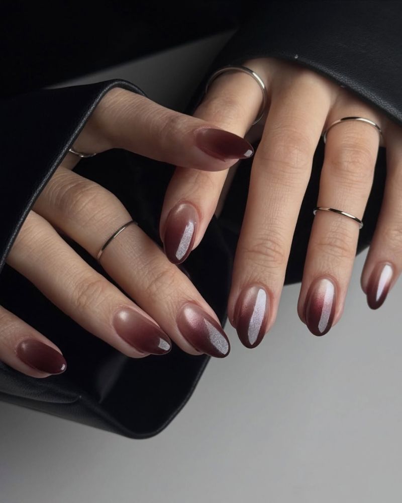short medium almond dark wine burgundy brown aura nails silver glitter shimmer sheer center fading from deep edges thin silver rings black leather bag