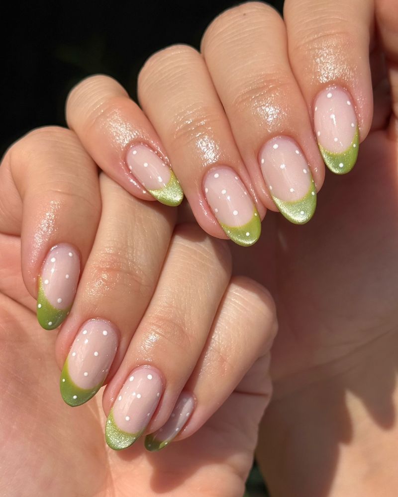 sheer jelly nails with green shimmer french tips and scattered white dots
