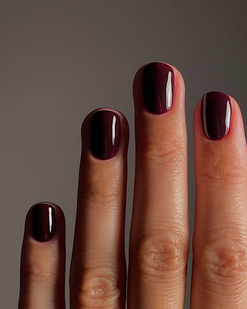 dark wine burgundy short oval nails high gloss two hands with diamond ring