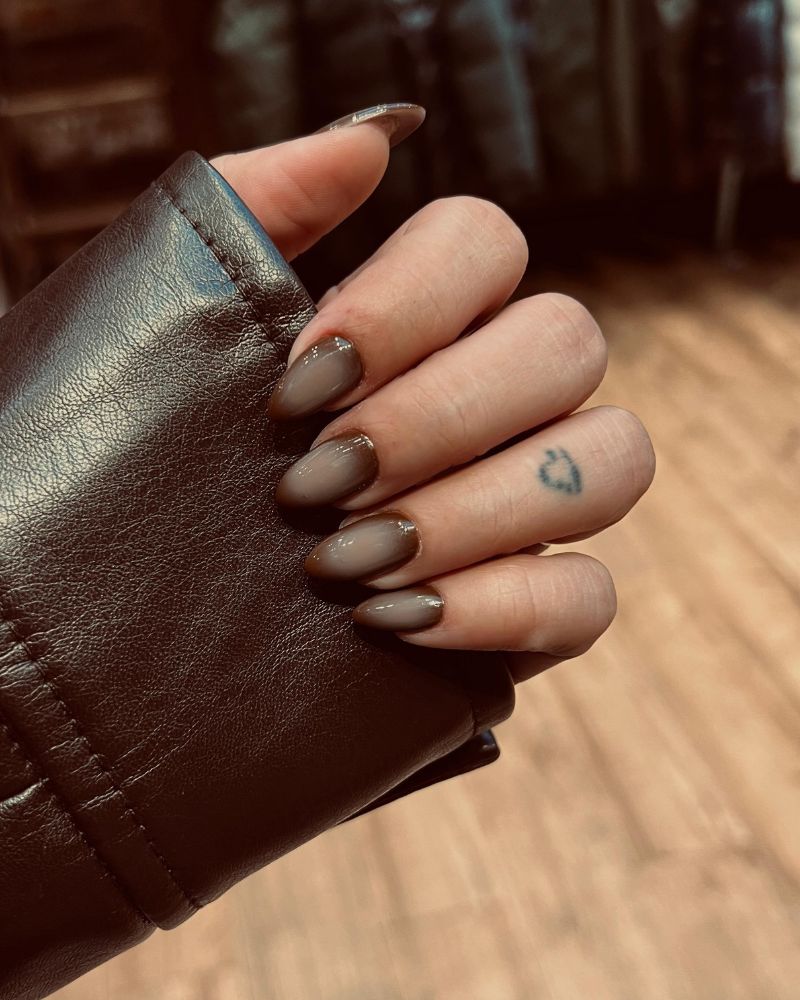 warm taupe brown medium almond nails against leather editorial shot
