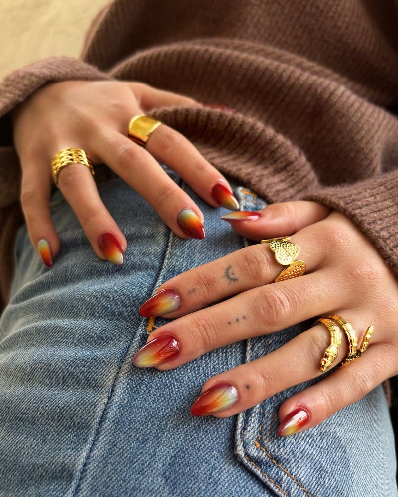 fire aura crimson almond nails with yellow orange burst center gold rings