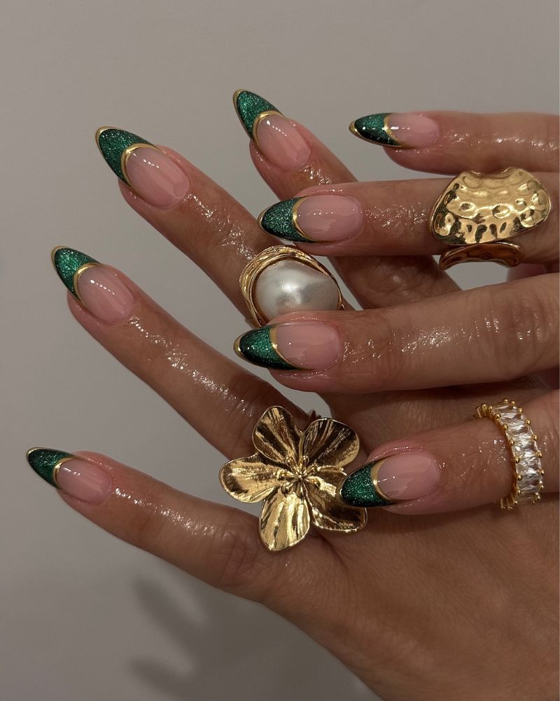 emerald green glitter french tips with gold outline on sheer stiletto nails