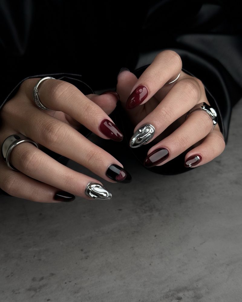 dark burgundy and black short oval nails with liquid silver chrome sculptural accent