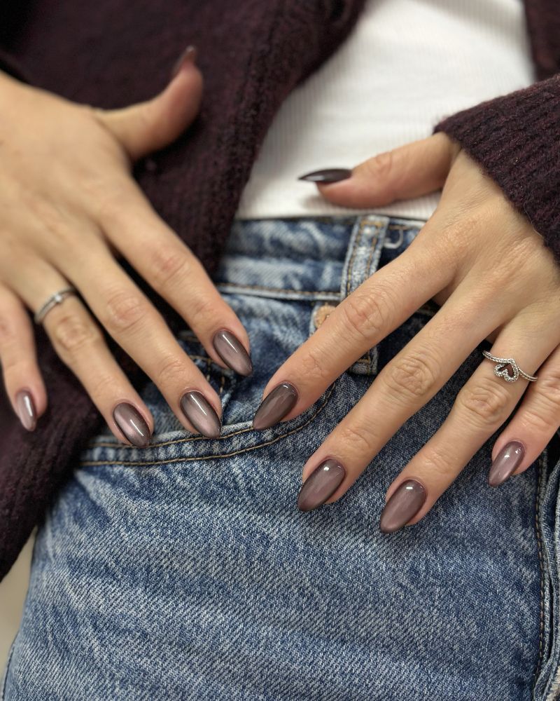dusty mauve brown pearl shimmer almond nails over jeans with burgundy knit